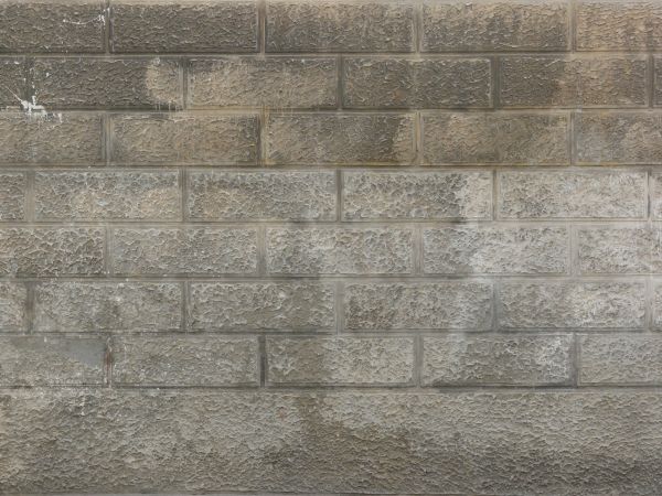 Grey brick wall with rough texture and soft hints of beige.